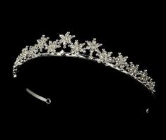 a tiara with flowers and pearls on the headband is shown against a black background