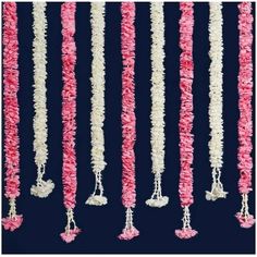 pink and white garlands hanging from strings in the shape of bells with tassels attached to them