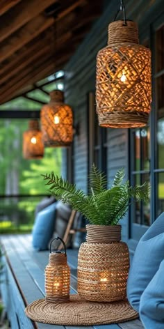 some lights hanging from the ceiling over a wooden table with blue cushions and pillows on it