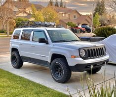 a white jeep parked in front of a house