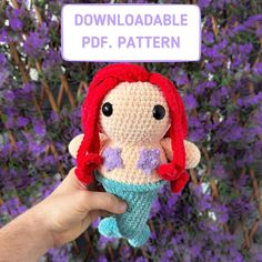 a crocheted little mermaid doll is held in front of purple flowers with a sign that reads, free pattern