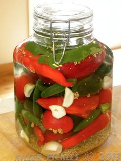 a glass jar filled with red and green peppers