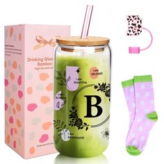 a glass jar filled with green liquid next to a pink box and socks on the floor