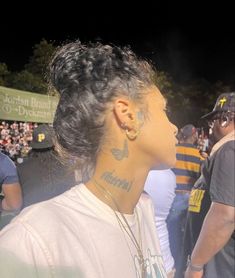 a woman with tattoos on her neck standing in front of a crowd