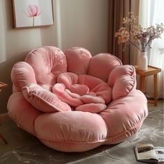 a pink bean bag chair sitting on top of a bed in a living room next to a window