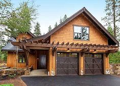 a large house with two garages in front of it and lots of trees around