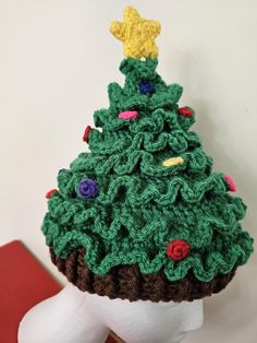 a crocheted christmas tree hat on top of a mannequin's head