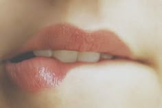 a woman's lips are shown with white teeth