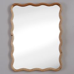 a wooden frame mirror hanging on the wall