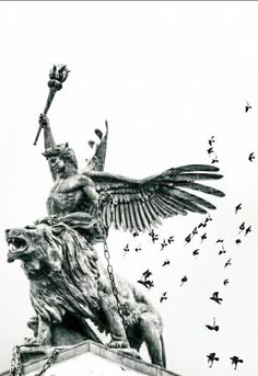 an image of a statue with birds flying around it