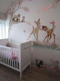 a baby's room decorated in pink and white with deers on the wall