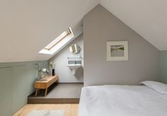 an attic bedroom with white bedding and wooden floors