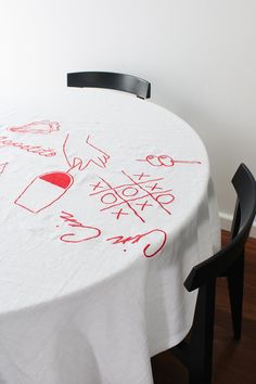 a white table with red writing on it and a black chair in front of it