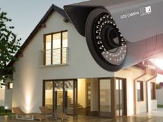 a camera attached to the side of a house in front of a lawn with lights