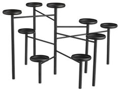 six black candlesticks are arranged in the shape of an eight - tiered candle holder