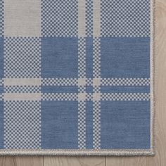 a blue and white rug on top of a wooden floor