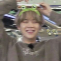 a young boy is smiling and holding his skateboard over his head