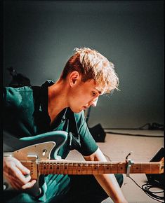 a young man is playing an electric guitar