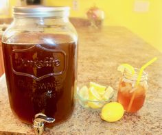 a mason jar filled with liquid sitting on top of a counter next to lemons