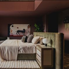 a bedroom with a bed, nightstands and paintings on the wall above it's headboard