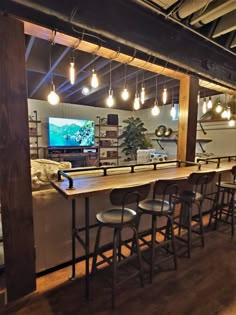 a bar with several stools in front of it and a television on the wall