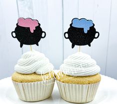 two cupcakes with white frosting and black silhouettes on top are sitting on a plate