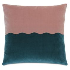 a pink and teal pillow on a white background