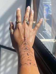 a woman's arm with tattoos on it and her hand holding onto the window sill