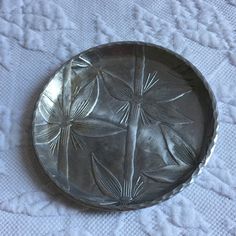 a metal plate sitting on top of a white cloth covered tablecloth with dragonflies