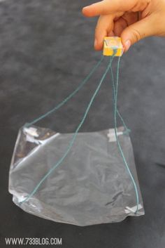 a person holding a plastic bag with string attached to it