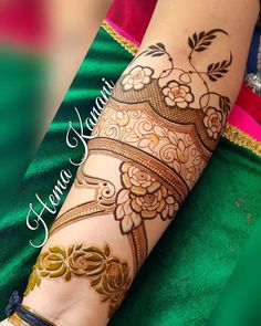 a woman's hand with henna tattoos on her left arm and the wrist