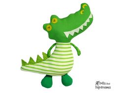 a stuffed alligator is wearing a striped shirt and green shoes with its mouth wide open