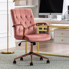 a pink office chair sitting in front of a desk with a computer monitor on it