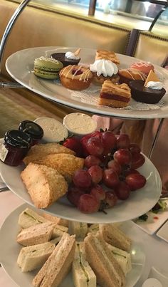 three tiered trays filled with different types of sandwiches and pastries on top of each other