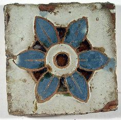 a blue and white tile with flowers on it