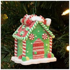 a christmas ornament hanging from a tree with candy canes and candies