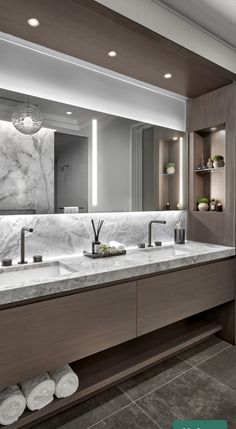 a large bathroom with two sinks and marble counter tops on both sides of the mirror