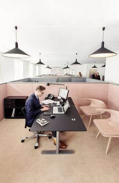 a man sitting at a desk using a laptop computer