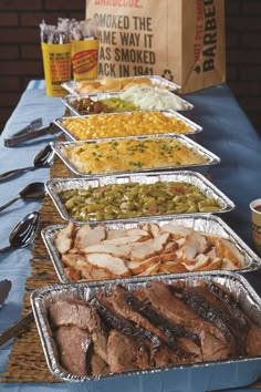 several trays of food are lined up on a table