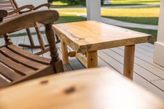 two wooden rocking chairs sitting on a porch