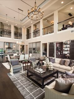 a living room filled with lots of furniture and a chandelier hanging from the ceiling