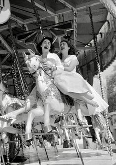 three women riding on a merry go round