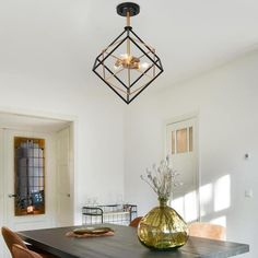 a dining room table with chairs and a vase on it