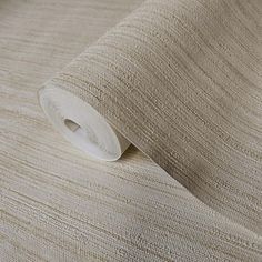 a roll of beige fabric on top of a white table cloth with a small hole in the middle