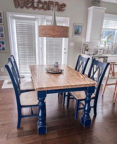 a wooden table with blue chairs in a kitchen