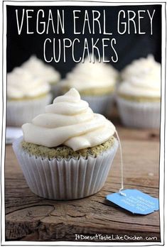 vegan cupcakes with white frosting on a wooden table next to a blue tag