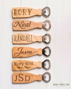 four pairs of personalized wooden wine openers with names on them, hanging from a white wall