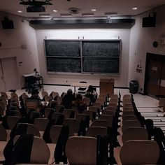 an empty classroom with chairs and a blackboard