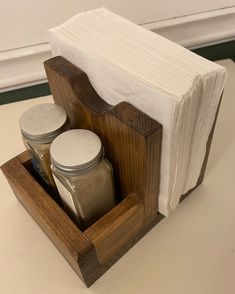 a wooden holder with jars and napkins in it