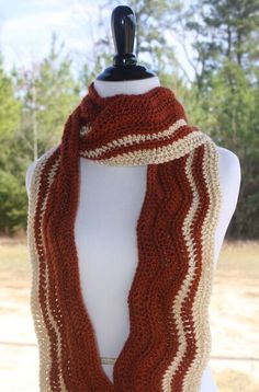 an orange and white knitted scarf on a mannequin